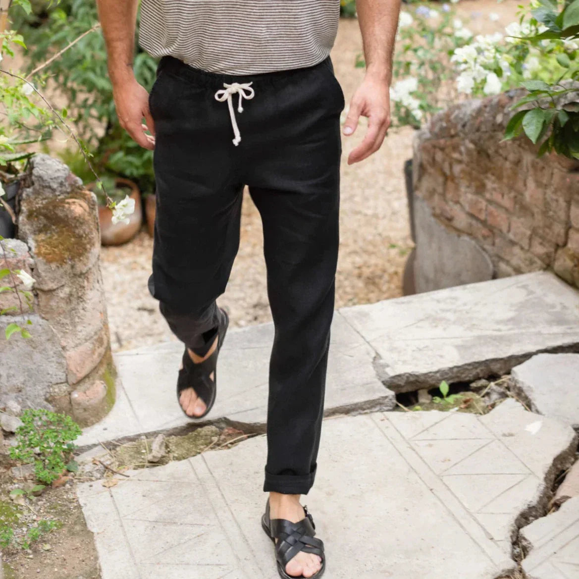 Alex Crane Modern Accessories Collection: man in black drawstring pants and sandals on a stone garden path