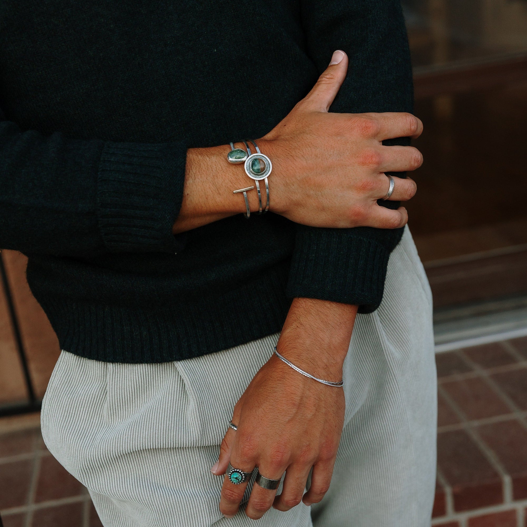 One Seed Designs nature-inspired jewelry featuring turquoise rings and silver cuffs on a model.