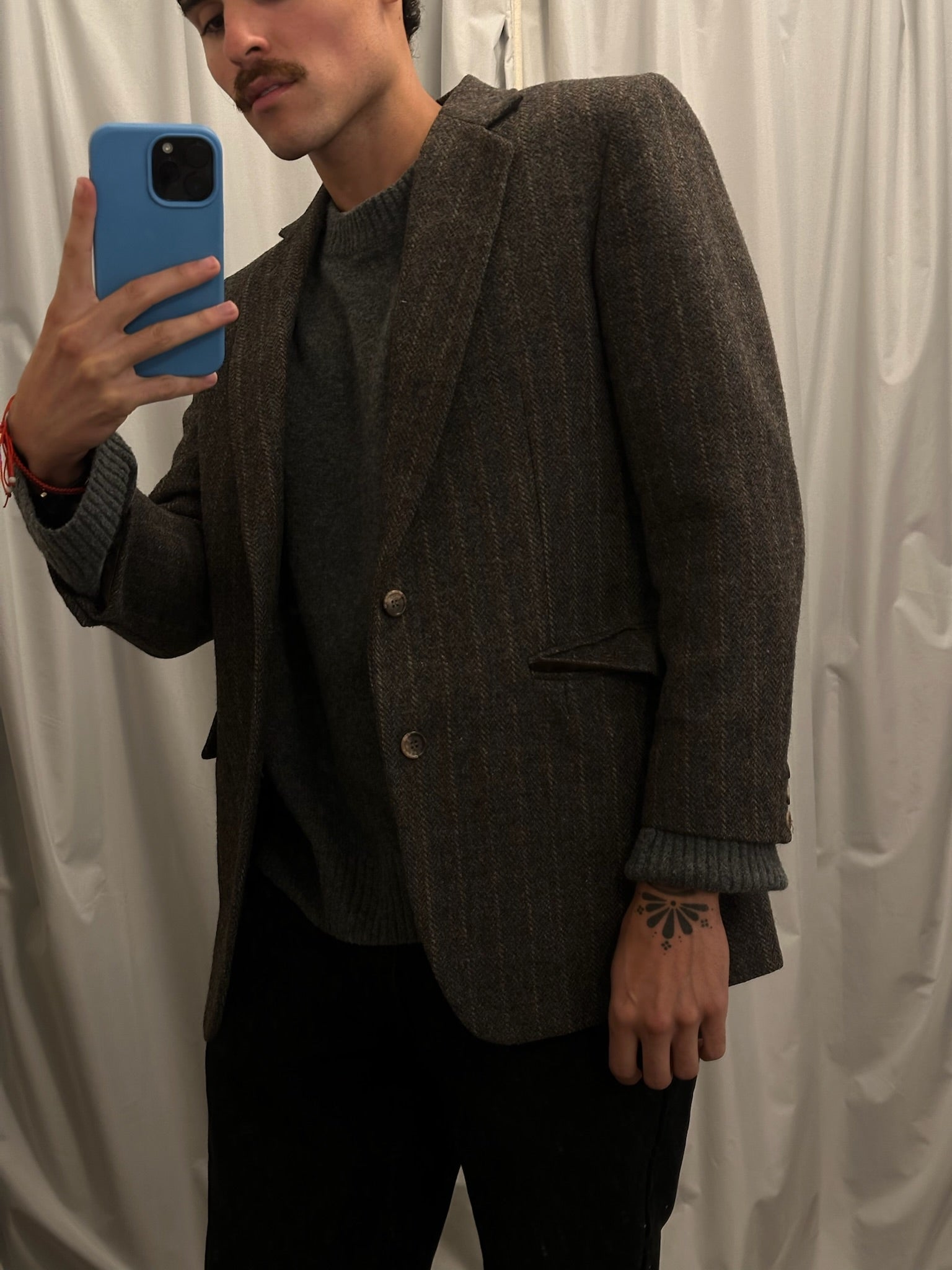 Pre-loved brown tweed blazer over gray knit sweater worn by a man in a mirror selfie