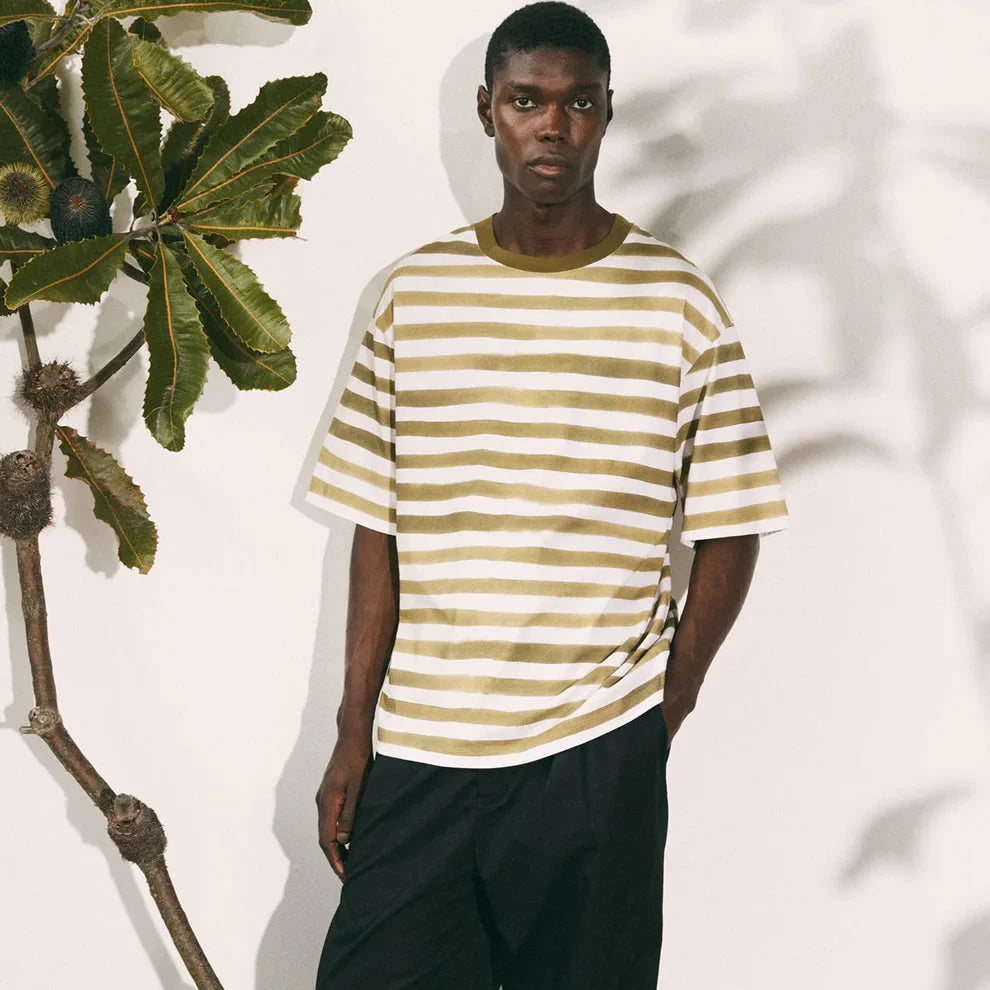 Kowtow Sustainable Clothing Collection Series: model in beige-white striped tee and black shorts.