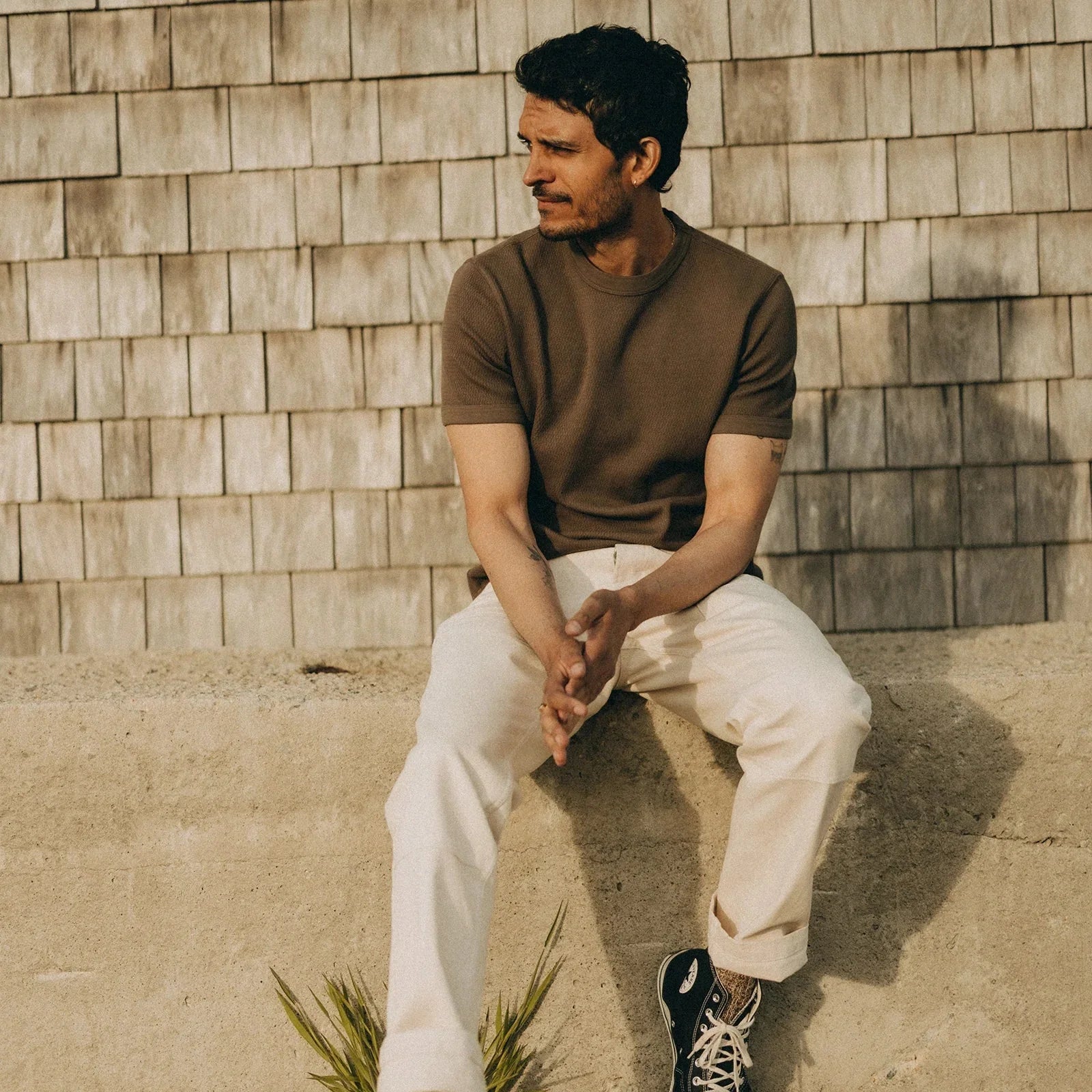 Man wearing a brown short-sleeve knit top and white pants, showcasing everyday Tops, Sweaters & Coats style.