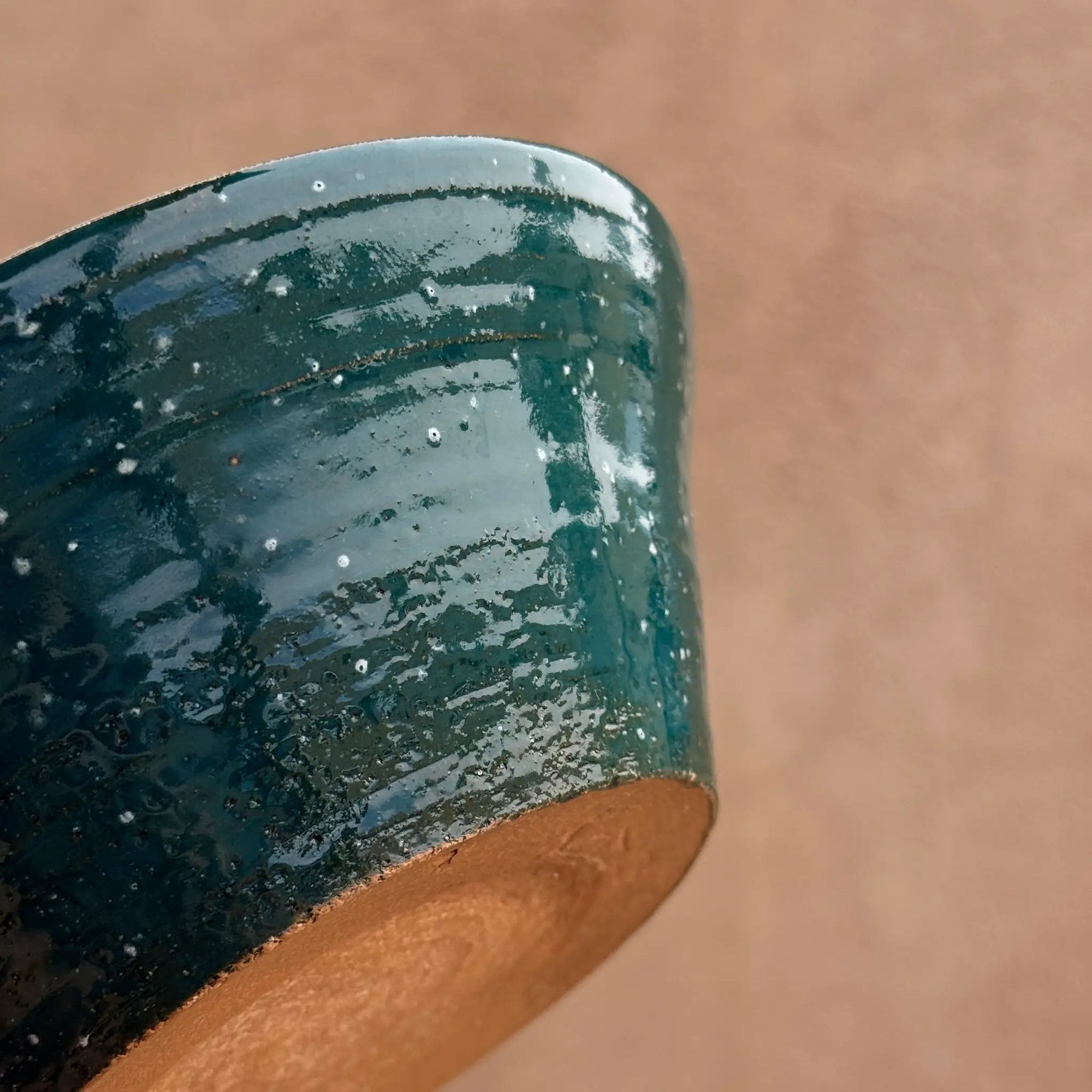 Pre-loved speckled ceramic bowl with light blue interior and green glaze, handcrafted.