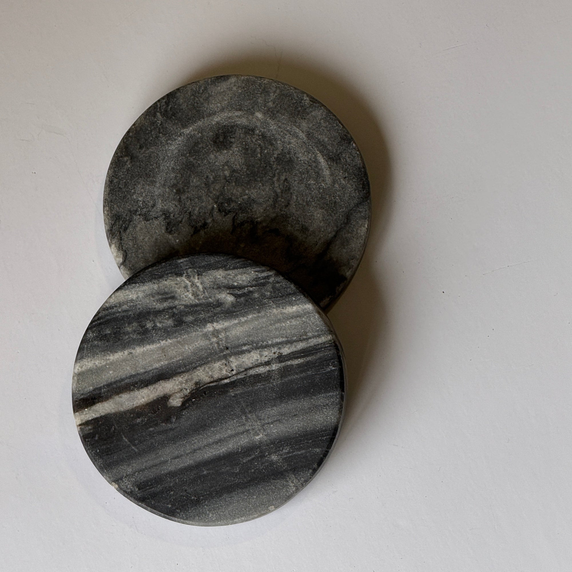 Two gray stone coasters on a white background